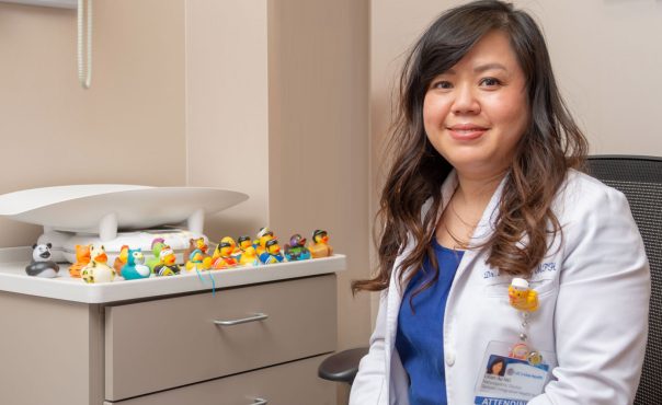 smiling doctor next to counter full of colorful rubber ducks