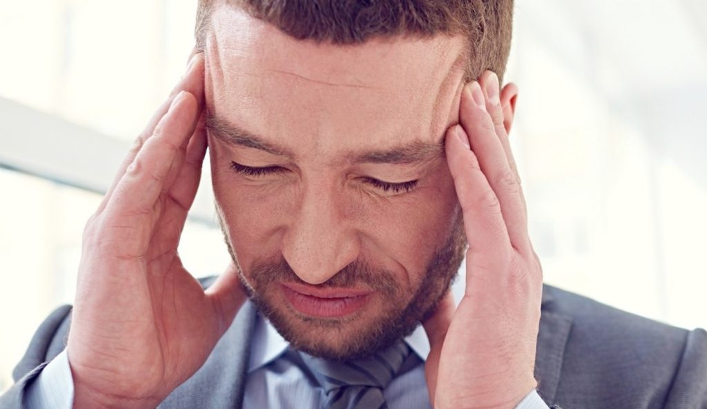 man in business attire suffering from headache